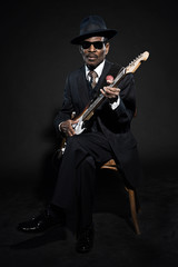 Obraz na płótnie Canvas Retro senior afro american blues man. Wearing striped suit with