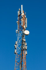 Communications tower with antennas on blue sky