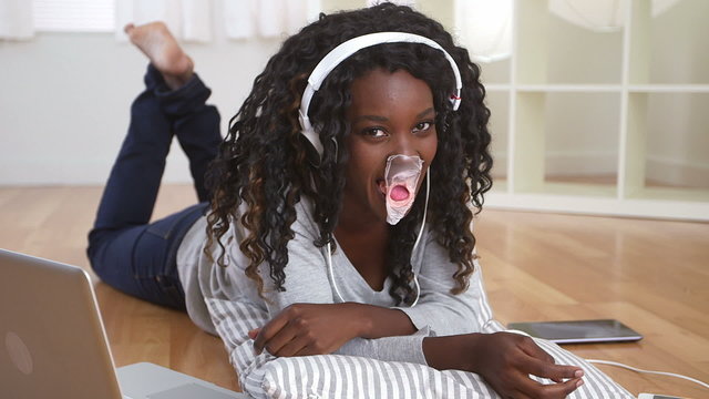 Cute black teenager blowing a bubble