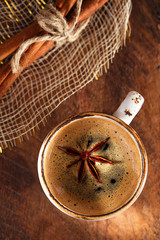 A cup of spiced coffee with anis star and cinamon sticks