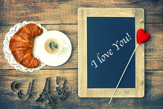 coffee with croissant, blackboard and heart decoration