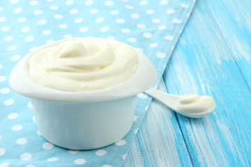 Sour cream in bowl on table close-up