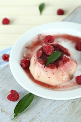 Panna Cotta with raspberry sauce, on wooden background