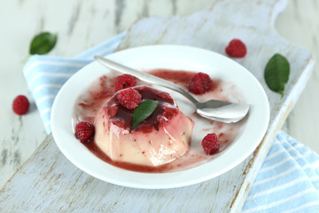 Panna Cotta with raspberry sauce, on wooden background