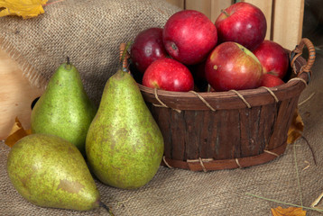 Ripe fruits in basket on sackcloth background