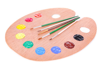 Wooden art palette with paint and brushes isolated on white