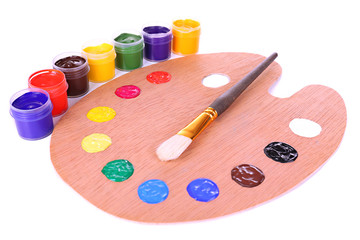Wooden art palette with paint and brush isolated on white