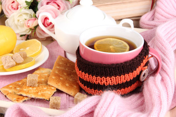 Cup of tea with lemon in scarf close up