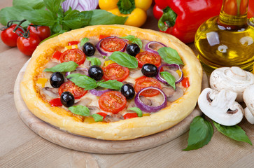 Tasty pizza and fresh ingredients on the table