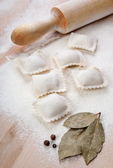 Raw pelmeni, black pepper and rolling pin