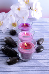 Obraz na płótnie Canvas Beautiful colorful candles, spa stones and orchid flower,on