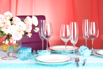 Table serving with colorful tableware on room background