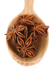 Gordijnen Star anise in wooden spoon, isolated on white © Africa Studio