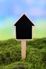 Small chalk board on grass on light background