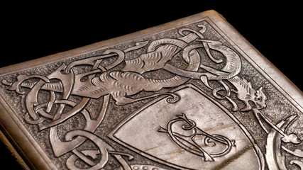 Old leather bound book with a dragon on the cover