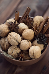 Walnuts, cinnamon and anise in a glass bowl, high angle view