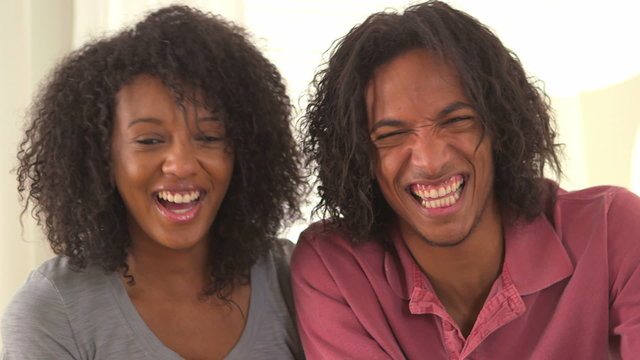 Black couple laughing at the camera