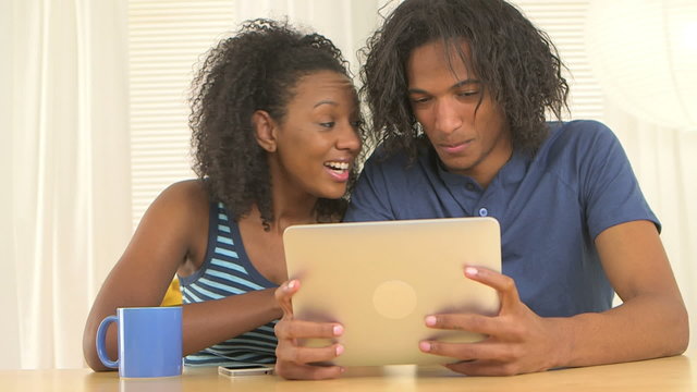 Black Couple Using Tablet At Desk