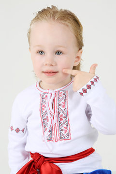 Happy little boy in russian national costume sits