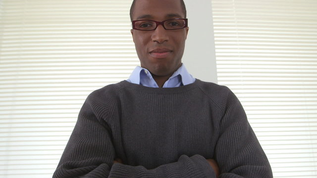 Confident African American business man crossing arms in office