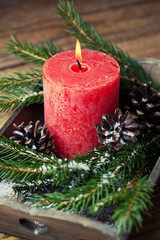 Christmas decoration with candle,  xmas tree branches and cones