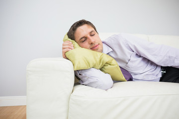 Fototapeta premium Tired businessman sleeping on sofa in living room