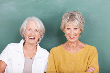 zwei ältere freundinnen vor einer schultafel