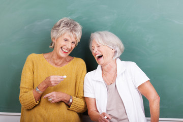 lachende seniorinnen vor einer schultafel