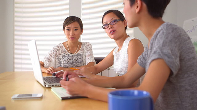 Chinese businesswomen analyzing data on laptop