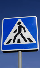 Дорожный знак "Пешеходный переход" на фоне синего неба