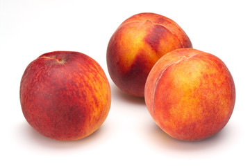 Three peaches isolated on white background