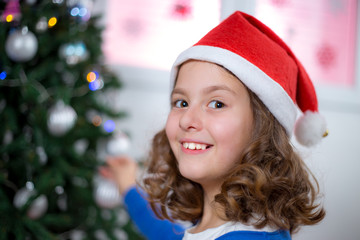 little girl decorates Christmas tree