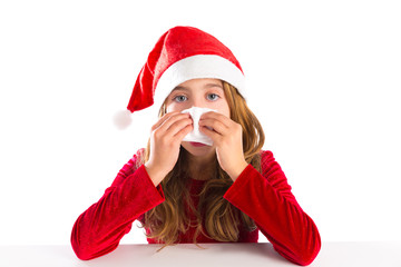 Christmas Santa kid girl blowing her nose in a winter cold