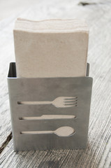 Recycled paper napkins in metal holder.
