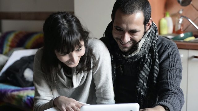 couple using tablet smiling at home