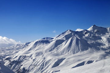 Fototapeta na wymiar View on ski slope and beautiful mountains at sunny day