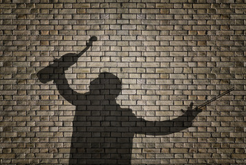 Silhouette of a violin player on brick wall