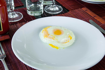 sunny side up fried egg on white plate on the dining table