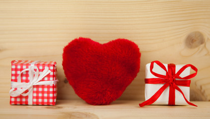 Herz mit Päckchen als Geschenke vor Holzhintergrund