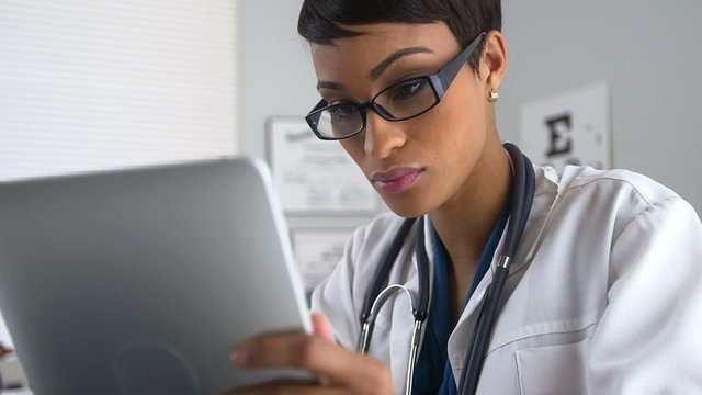 Doctor using tablet pc and laptop computer