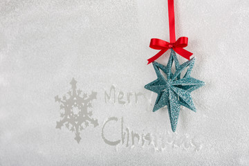 Snow on the frozen window with word " Merry Christmas " and snow