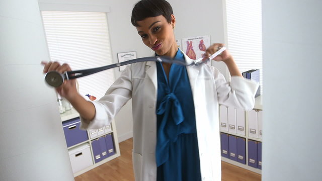 Cute female doctor dancing in the office