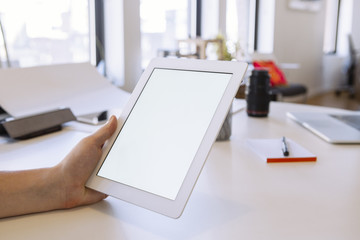 Person in the office holding a touch screen device.