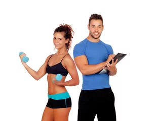 Tuinposter Handsome personal trainer with beautiful girl with dumbbells © Gelpi