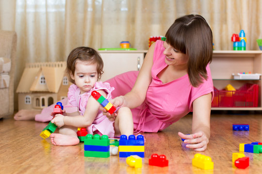 mother and her child play block toys at home