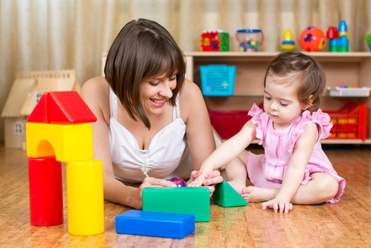 mother and her kid play with toys indoors