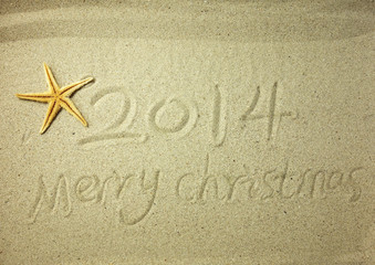 Merry Christmas 2014 handwritten in sand on a beautiful beach