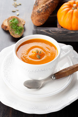 Pumpkin soup with pumpkin seeds, bread, and raw pumpkin