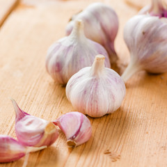 raw garlic on a wooden plank
