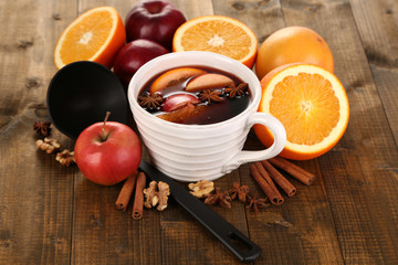 Fragrant mulled wine in bowl on wooden table close-up